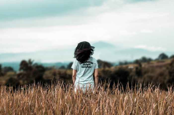 selective focus photography of woman standing on wheat field